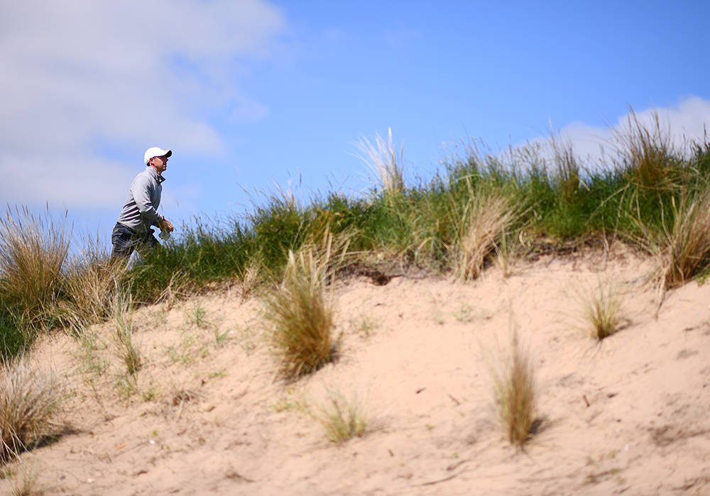 Rory McIlroy walking up the dunes